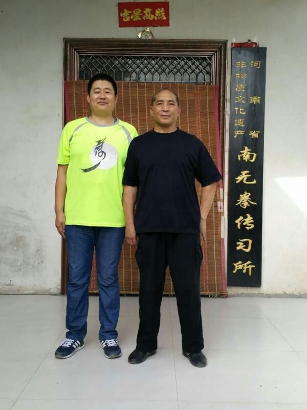 Two men pose together.